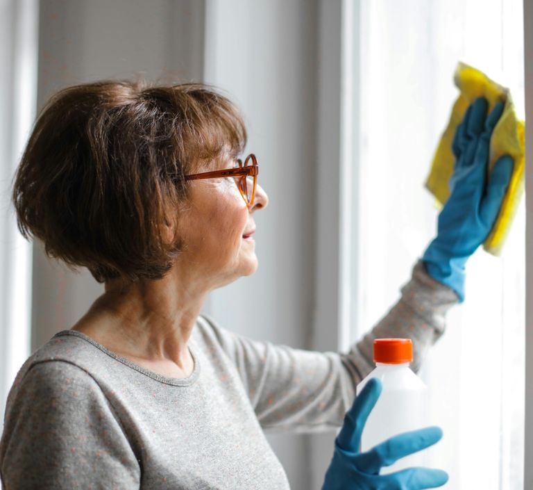 Frau reinigt Fenster - haushaltsnahe Dienstleistung für alle